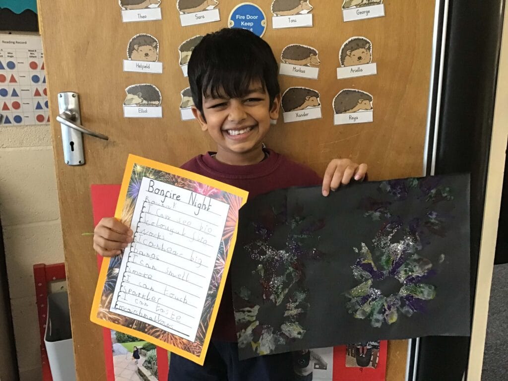 Young child holding a drawing.