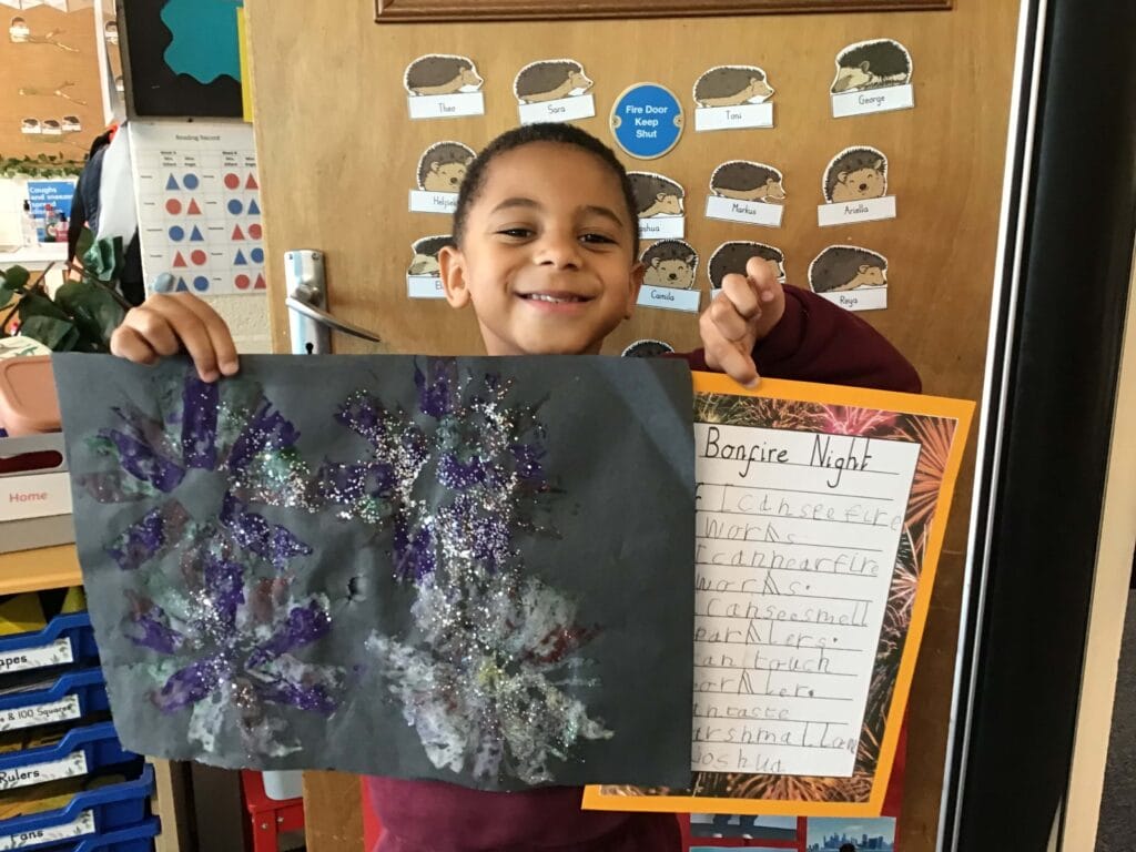 Young child holding a drawing.