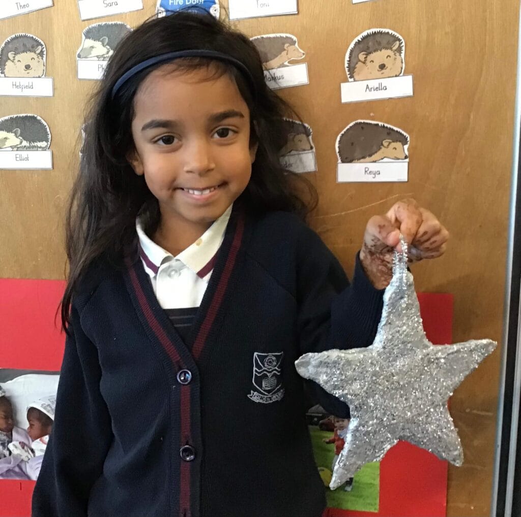 Young child holding a crafted star.