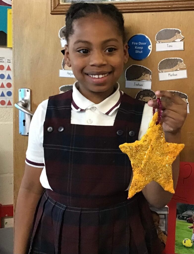Young child holding a crafted star.